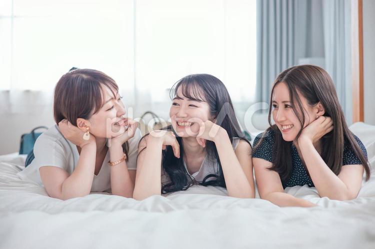 旅行の宿泊先に着いた女性たち（ベッド） 旅行,旅,女子旅の写真素材