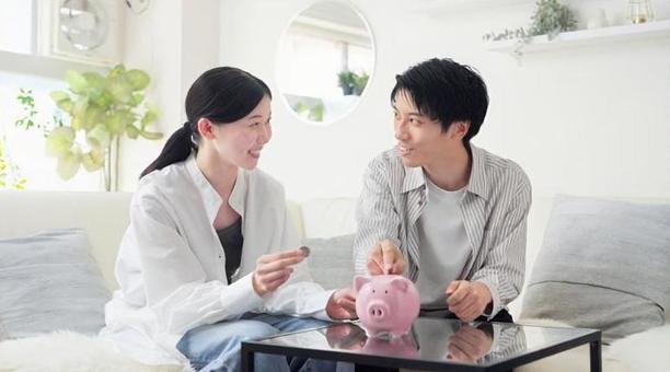 貯金箱にお金を入れるアジア人のカップル 貯金箱にお金を入れるアジア人のカップル 貯金,カップル,女性の写真素材