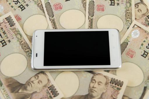 スマートフォンと日本円札 スマートフォンと日本円札の写真