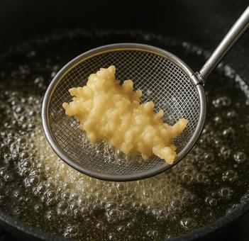 天ぷらを油から掬い上げる瞬間 天ぷらを油から掬い上げる瞬間の写真