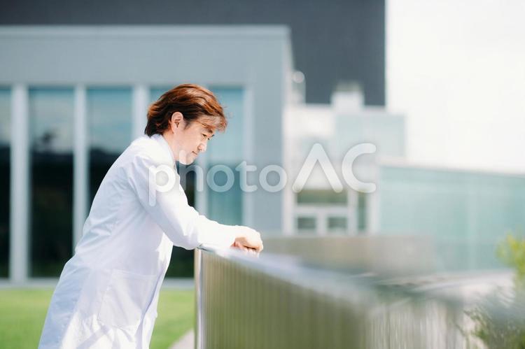 屋上で考える白衣の男性 医者,悩み,考えるの写真素材