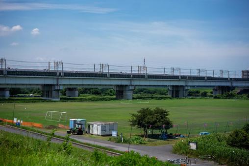 青空と緑の河川敷グラウンド 河川敷,グラウンド,芝生の写真素材