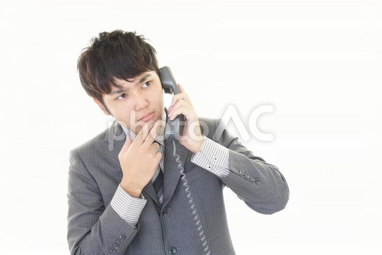 受話器を持って考える男性 男性,電話,考えるの写真素材
