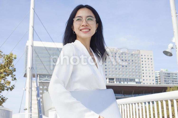 パソコンを持ち振り向く女性 女性,パソコン,ノートパソコンの写真素材