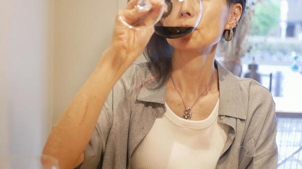 赤ワインを飲む女性 赤ワインを飲む女性 女性,ワイングラス,食事中の写真素材