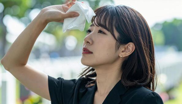 葬儀の時、涙を拭う喪服姿の日本人女性の写真