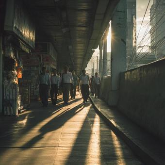 夕暮れに長い影を落とす都市の歩行者 夕暮れに長い影を落とす都市の歩行者の写真