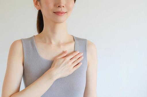 胸に手を当てる女性 胸に手を当てる女性の写真