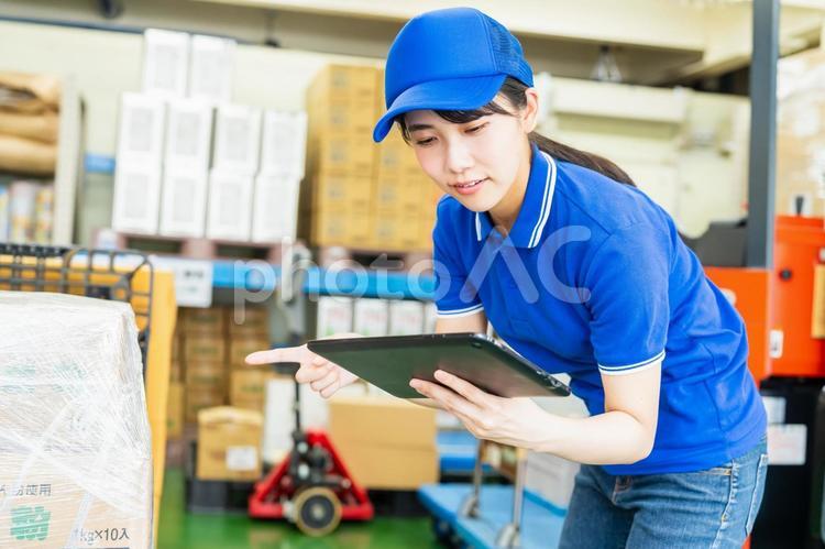荷物を管理する若い女性 倉庫,工場,笑顔の写真素材