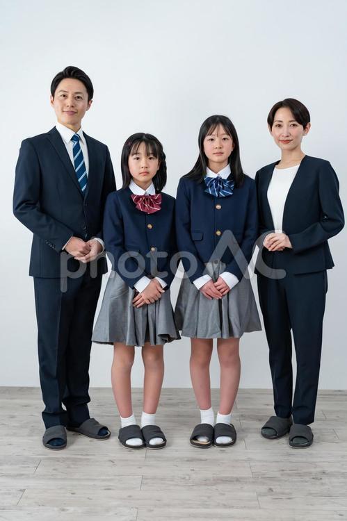スーツを着た男女と制服を着た女の子二人 入学式,父母,母親の写真素材