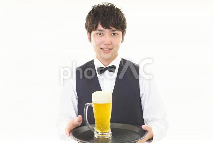 ビールジョッキを運ぶ笑顔のウェイター 男性,ウェイター,ビールの写真素材
