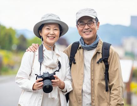 カメラを持って旅する仲良しシニア夫婦の写真