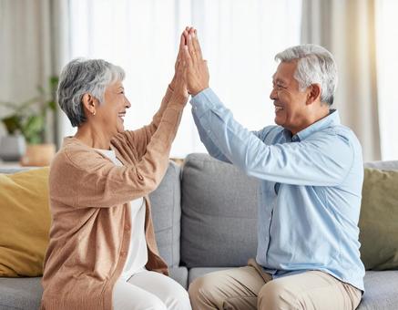 ハイタッチするシニア夫婦の写真