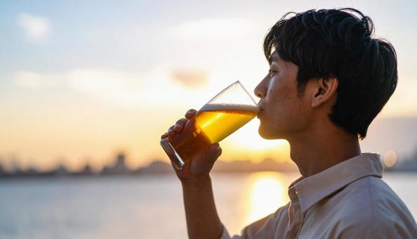 ビールを飲む若い男性のポートレート ビールを飲む若い男性のポートレートの写真
