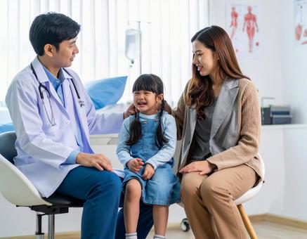 小児科で幼児を診察する医者 小児科で幼児を診察する医者の写真