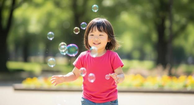シャボン玉で遊ぶ笑顔の女の子 シャボン玉で遊ぶ笑顔の女の子の写真