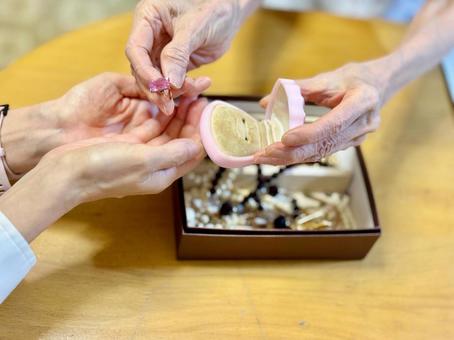 指輪を女性に渡す高齢女性の手 指輪を女性に渡す高齢女性の手の写真