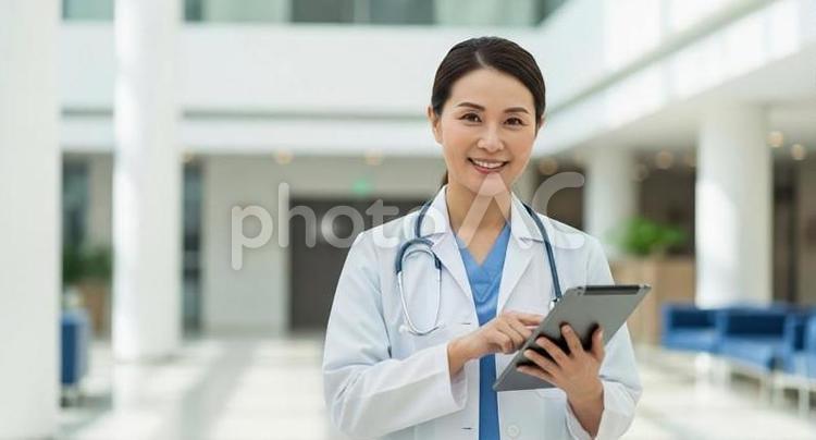 病院のロビーでタブレットを操作する医師 医者,医師,女性の写真素材