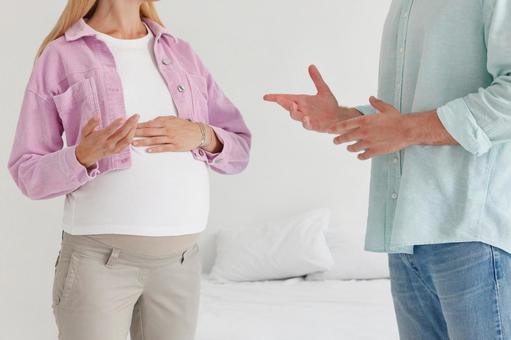 ベッドの前で話す夫婦の手元の写真