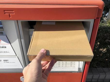 Dropping a cardboard package into a mailbox, JPG Dropping a cardboard package into a mailbox, JPG