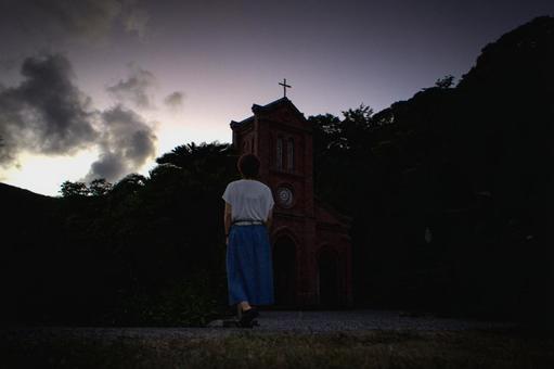 ＜素材＞夕暮れ観光地の教会を散策する女性の写真