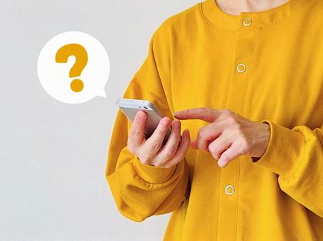 はてなマークを浮かべるスマホ操作中の女性 わからない,女性,スマホの写真素材