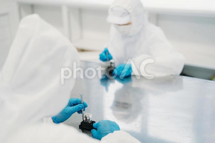 クリーンルームで精密機器を扱う女性 工場,製造業,精密機器の写真素材
