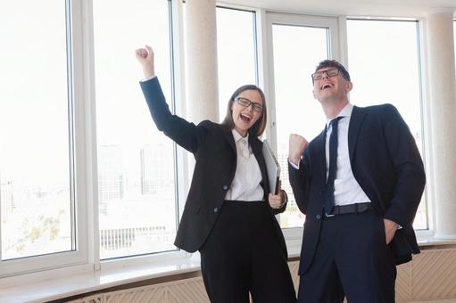 カメラ目線でガッツポーズで喜ぶ男女 男女,ガッツポーズ,笑顔の写真素材