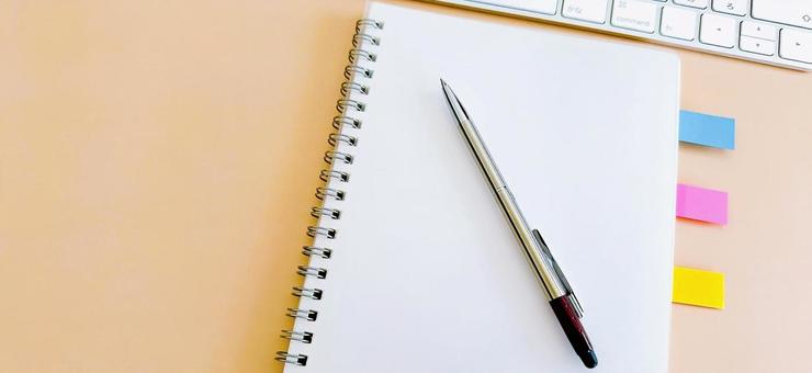 筆記用具 付箋の付いたノートとボールペン 筆記用具 付箋の付いたノートとボールペンの写真