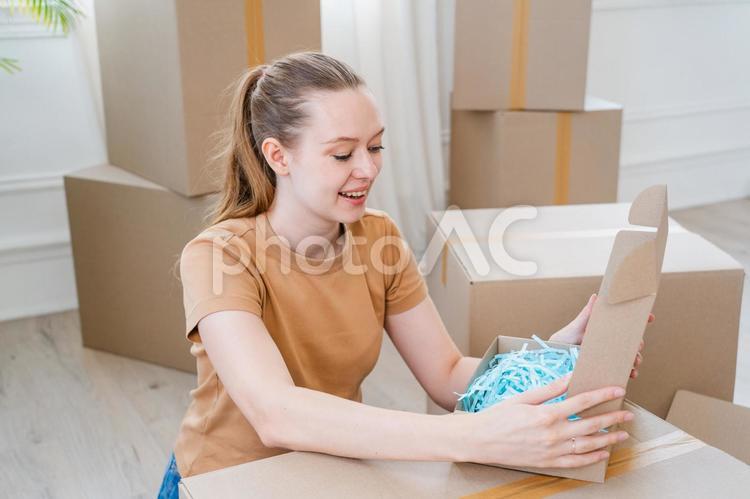箱を開け笑顔の女性 女性,荷造り,笑顔の写真素材