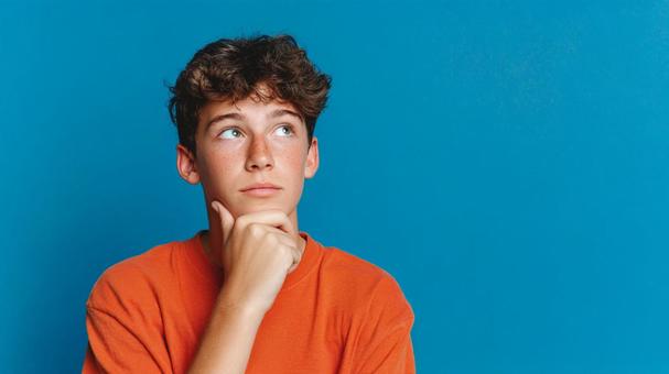 考え込むティーンエイジャーの男性 考え込むティーンエイジャーの男性の写真
