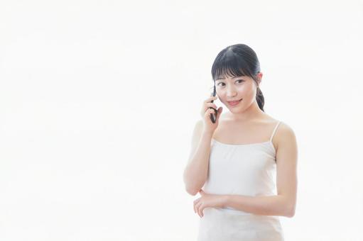 スマホで通話をする若い女性 スマートフォン,キャリア,風呂上がりの写真素材