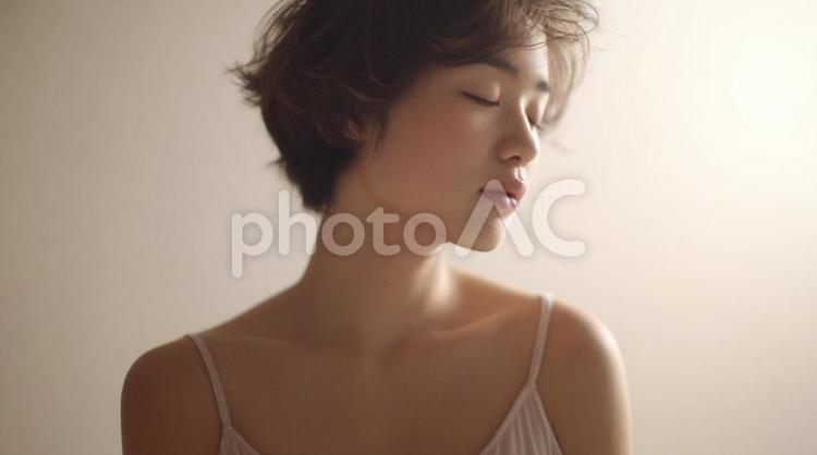 目を閉じて穏やかな表情を浮かべる若い女性 穏やか,表情,目を閉じるの写真素材