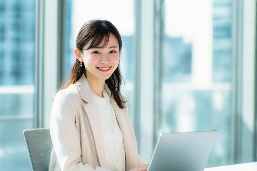 ノートパソコンを使用する女性会社員 ノートパソコンを使用する女性会社員の写真