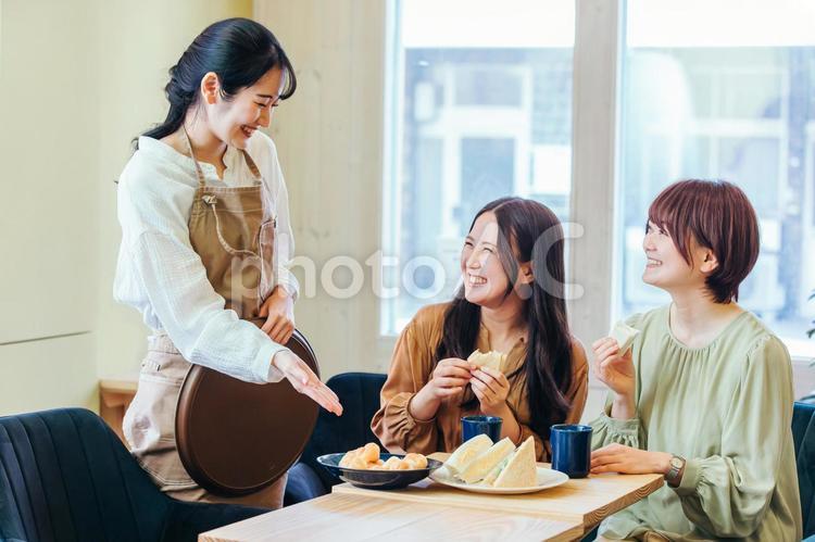 レストランで食事する女性とホールスタッフ 飲食店,レストラン,カフェの写真素材