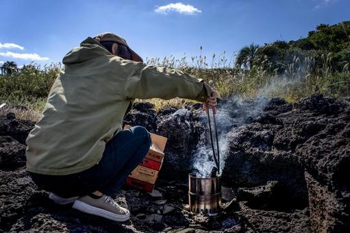 ＜素材＞秋のキャンプで火おこしをする女性 女性,キャンプ,焚き火の写真素材
