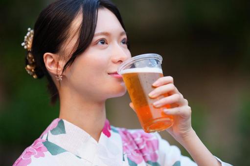 浴衣姿の女性が飲み物を掲げて楽しむ 女性,ビール,飲むの写真素材