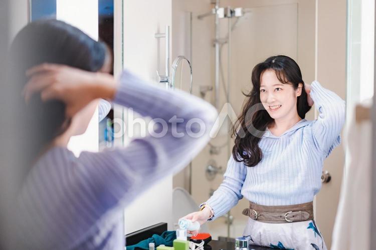鏡の前で髪のセットをする若い女性 女性,黒髪,女優の写真素材