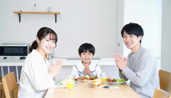 笑顔でいただきますをする家族の写真