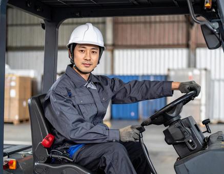 フォークリフトを運転する男性作業員の写真