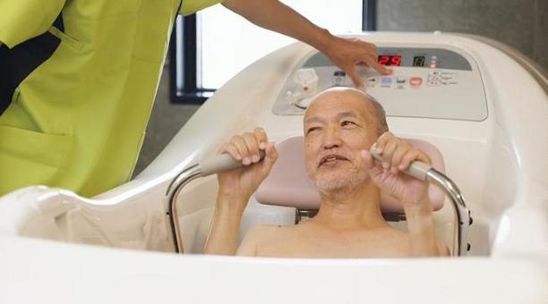 機械浴で入浴介助を受けるアジア人高齢者 機械浴で入浴介助を受けるアジア人高齢者 高齢者,機械浴,入浴の写真素材