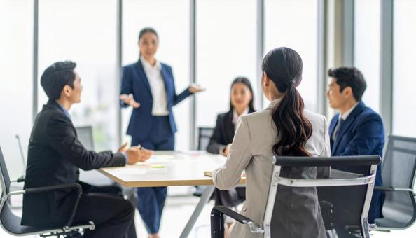 会議で発言をする女性社員 会議で発言をする女性社員の写真