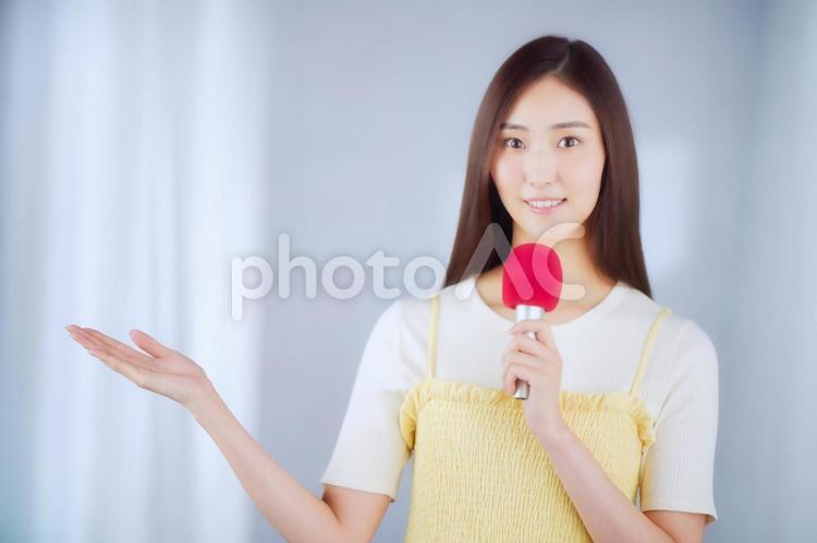 マイクを持ち喋る女性 女性,マイク,説明の写真素材