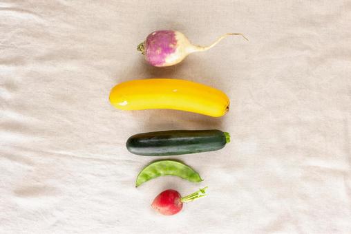 中央に縦に並ぶカラフルな野菜 中央に縦に並ぶカラフルな野菜の写真