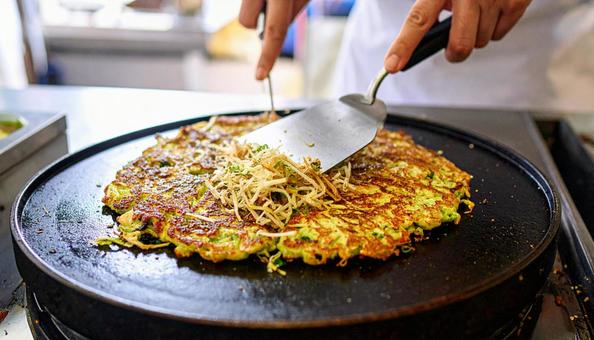 お好み焼きを鉄板で焼く お好み焼きを鉄板で焼くの写真