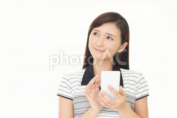 スマートフォンを持つ笑顔の女性 女性,スマートフォン,女の写真素材