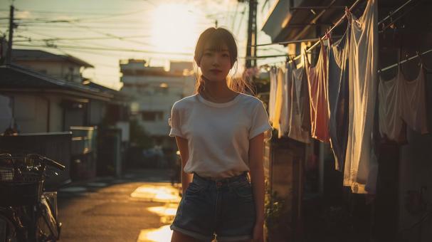 路地に立つTシャツとショートパンツの女性 路地に立つTシャツとショートパンツの女性の写真