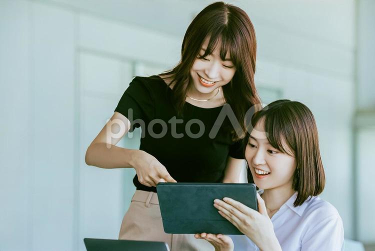 タブレットの画面を見る2人のビジネス女性 女性,ビジネス,ビジネスウーマンの写真素材