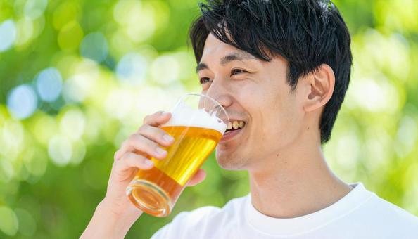 ビールを飲む若い男性のポートレート ビールを飲む若い男性のポートレートの写真