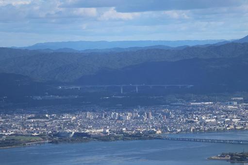 琵琶湖と橋と街並みと山並みと高速道路と空 琵琶湖と橋と街並みと山並みと高速道路と空の写真